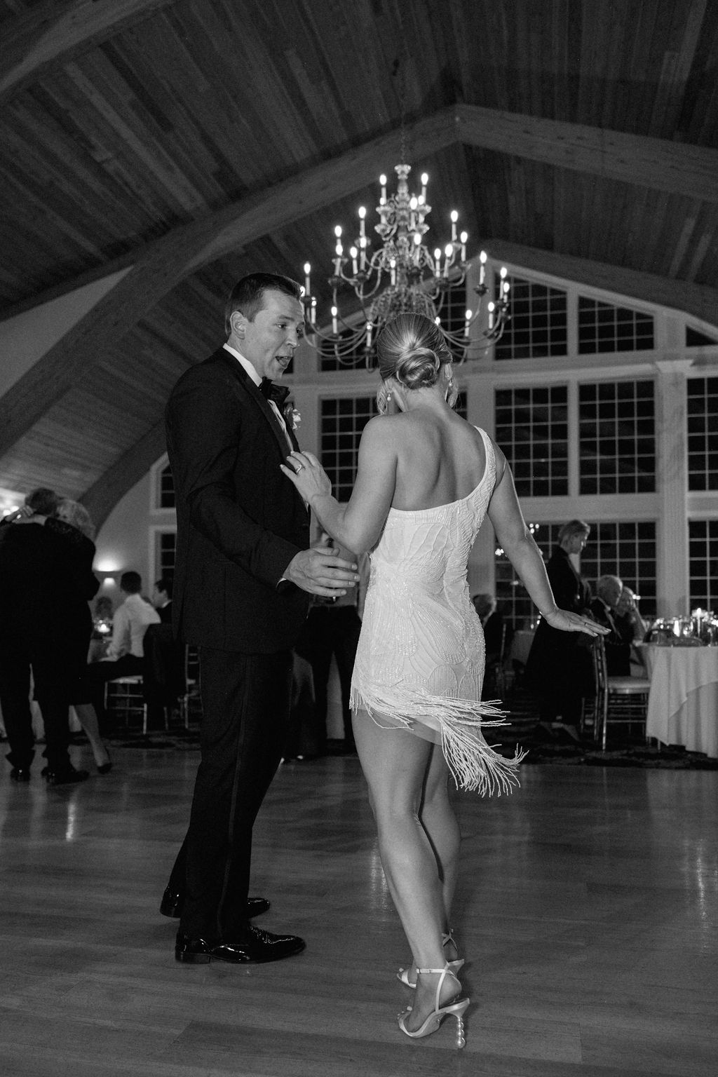 Bride in short reception dress, dancing with groom at wedding reception