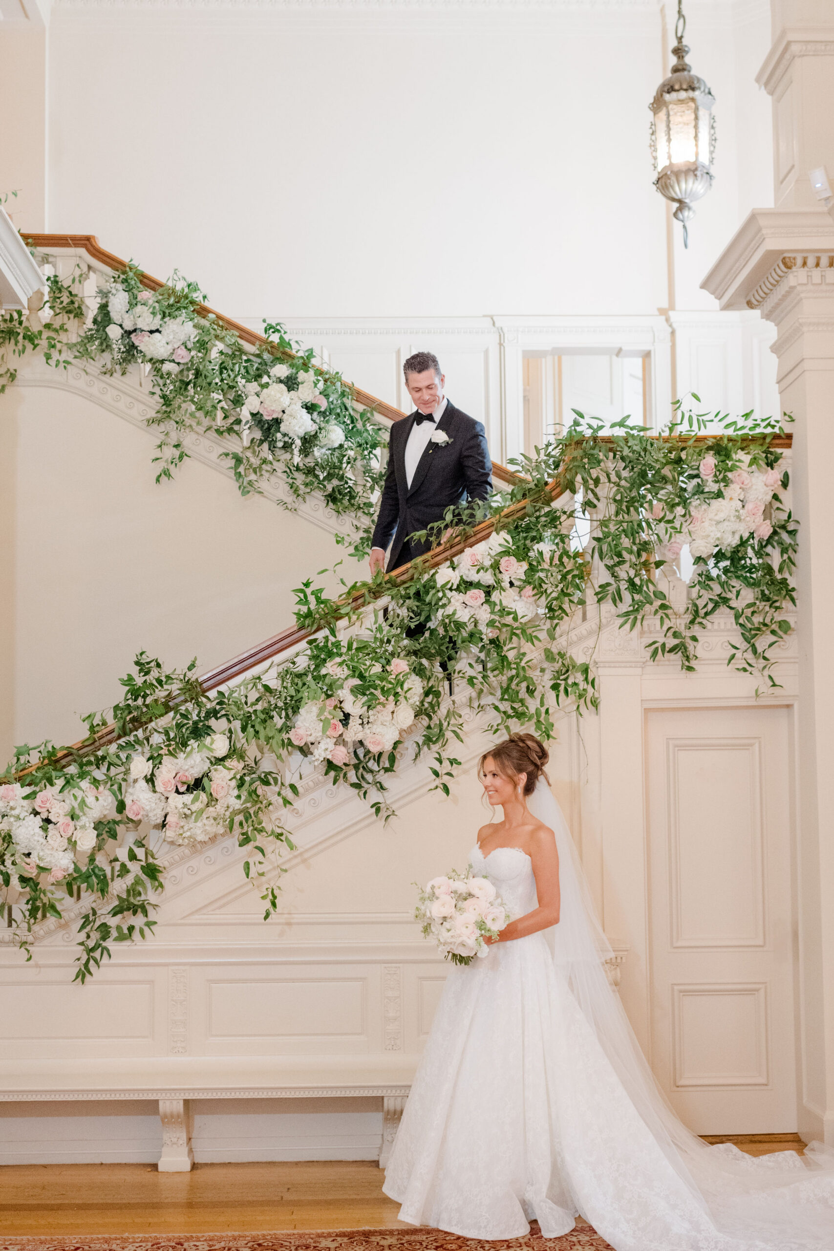 Couple pose for wedding photos at grand stairway at Cairnwood Estate