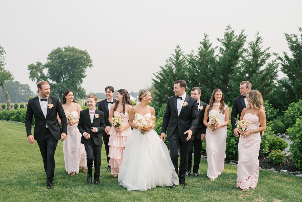 Newly married couple walk with wedding party after ceremony at Glen Foerd